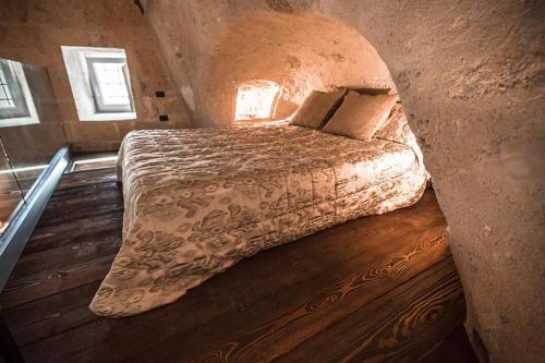 una camera con un grande letto in una parete in pietra di SUITE LA STALLA a Matera
