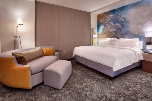 a hotel room with a bed and a couch at Courtyard by Marriott Lehi at Thanksgiving Point in Lehi