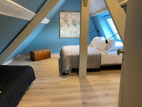 une chambre mansardée avec deux lits et une fenêtre dans l'établissement Le Flamand, à Saint-Omer