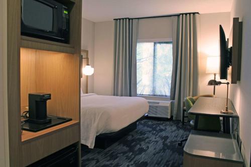 a hotel room with a bed and a window at Fairfield by Marriott Inn & Suites St Louis South in Saint Louis