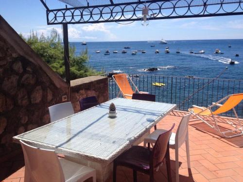 a table and chairs on a patio with a view of the ocean at L'Oblò in Massa Lubrense