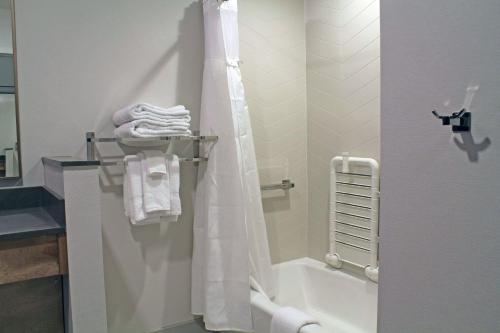 uma casa de banho com um chuveiro e uma banheira com toalhas em Fairfield by Marriott Inn & Suites St Louis South em Saint Louis