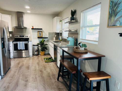 a kitchen with a counter and a refrigerator and a table at Tropical Casita in Tampa near airport and Raymond James stadium in Tampa