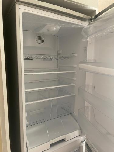 um frigorífico branco com a sua porta aberta com as suas prateleiras em Beautifull New 2 Bedroom Apartment in Amman em Amã