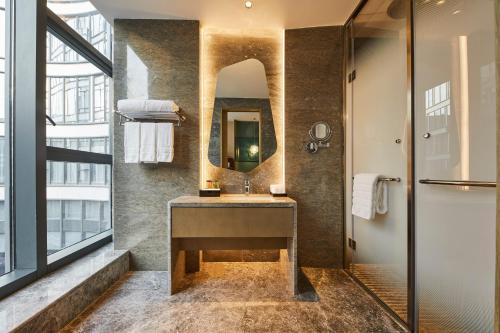 a bathroom with a sink and a mirror at The Westin Qingdao West Coast in Huangdao