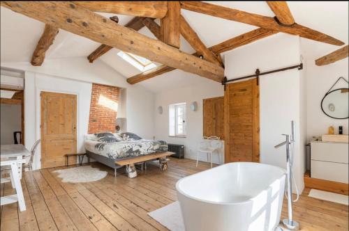 uma casa de banho com banheira num quarto com tectos em madeira em Aux Tourelles 1888 - tres proche Lyon em Tassin-la-Demi-Lune