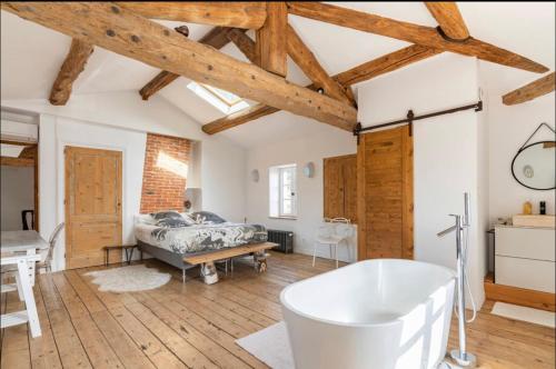 a bathroom with a bath tub in a room with wooden ceilings at Aux Tourelles 1888 - Tres Proche Lyon #Clim #Piscine #Netflix #Parking Payant Securise in Tassin-la-Demi-Lune