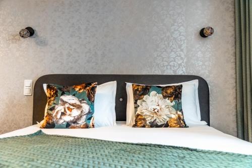 une chambre avec un lit avec deux oreillers dans l'établissement Escapade Place 11 N4 - Studio Dinan Centre, à Dinan