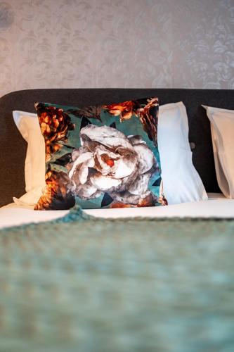 - un oreiller avec une fleur sur le lit dans l'établissement Escapade Place 11 N4 - Studio Dinan Centre, à Dinan