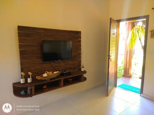 a living room with a flat screen tv on a wall at Home suíte taipu in Marau