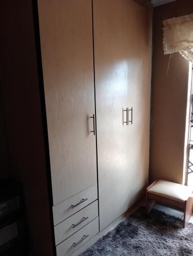 um armário com armários brancos e uma janela em moafrikatravellodge em Lydenburg