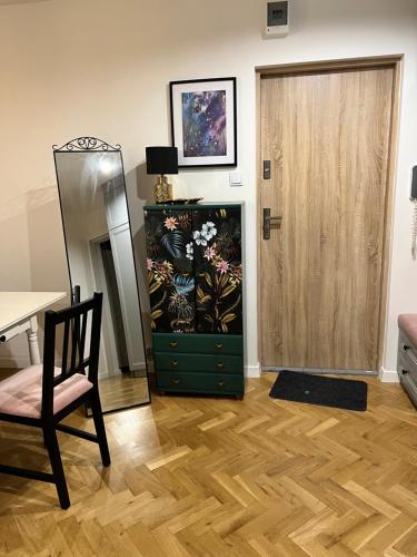 a room with a dresser and a door and a chair at Apartment by Chopina Street in Konin