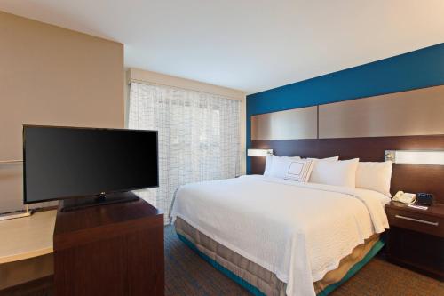 a hotel room with a bed and a flat screen tv at Residence Inn Palo Alto Mountain View in Mountain View