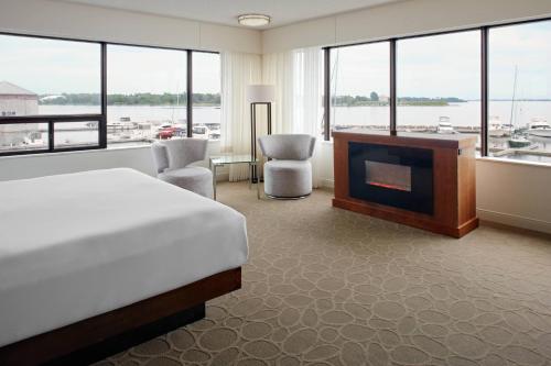 1 dormitorio con 1 cama, chimenea y TV en Delta Hotels by Marriott Kingston Waterfront, en Kingston