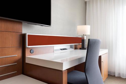 a hotel room with a desk and a tv at Delta Hotels by Marriott Indianapolis Airport in Indianapolis
