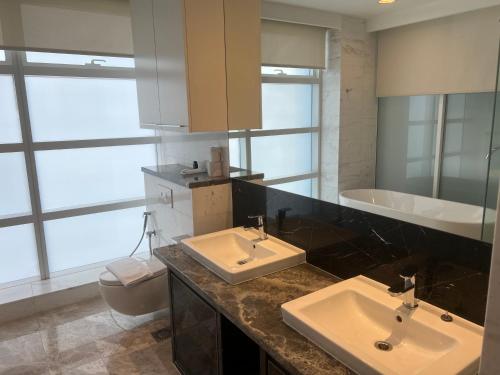 a bathroom with two sinks and a tub and a toilet at Pool View Platinum KLCC in Kuala Lumpur