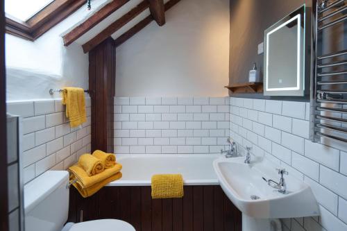 bagno con vasca, lavandino e servizi igienici di Brynarth Country Cottages ad Aberystwyth