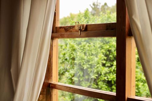an open window with a view of trees at Hotel Boutique Casa Werner in Puerto Varas