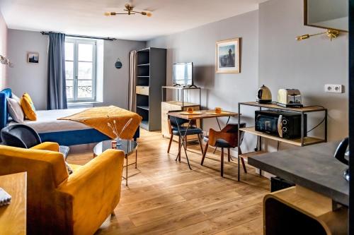 een kamer met een bed, een tafel en stoelen bij Escapade Place 11 N3- Studio Dinan centre in Dinan