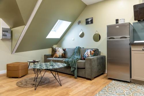 un salon avec un canapé et une table dans l'établissement Escapade Place 11 N5A - Appartement Dinan centre, à Dinan