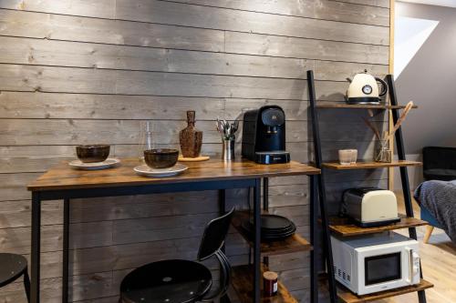a room with a wooden wall with a table and a microwave at Escapade Place 11 N5B - Studio Dinan centre in Dinan