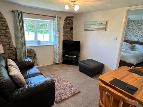 a living room with a couch and a bed at Moorhead Country Holidays in Bideford