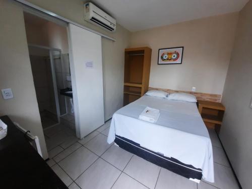 een kleine slaapkamer met een bed en een douche bij Hotel Oiticica in Fortaleza