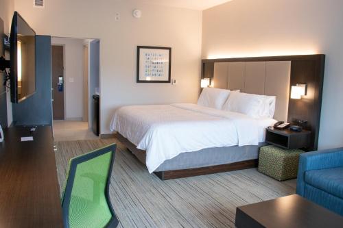 um quarto de hotel com uma cama grande e um sofá em Holiday Inn Express & Suites - Tuscaloosa East - Cottondale, an IHG Hotel em Cottondale