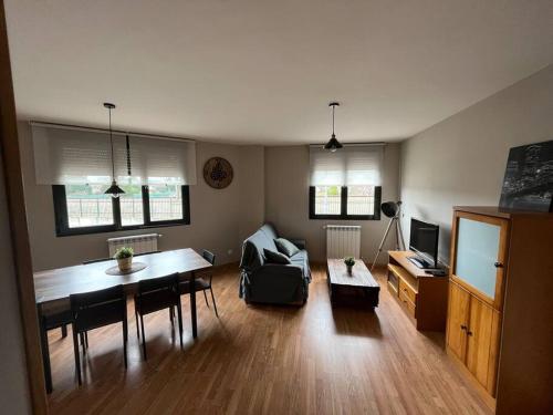 uma sala de estar com uma mesa e um sofá em Apartamento Ahola II em Ponferrada