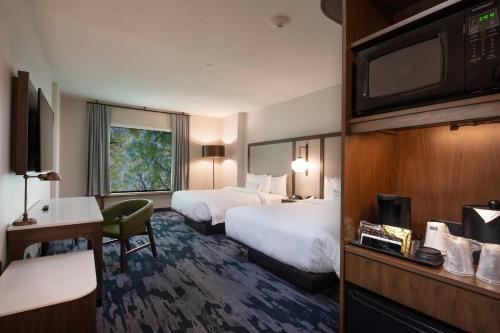 a hotel room with two beds and a flat screen tv at Fairfield by Marriott Edmonton International Airport in Edmonton