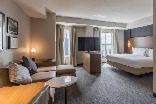 a hotel room with a bed and a couch at Residence Inn by Marriott Halifax Downtown in Halifax