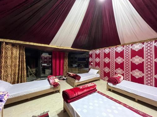 a room with three beds in a tent at Bedouin Holidays Camp and Jeep Tours in Wadi Rum