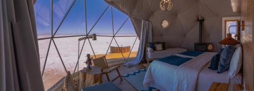 a bedroom with a bed and a view of the desert at Salinas Grandes Jujuy - Pristine Luxury Camp 