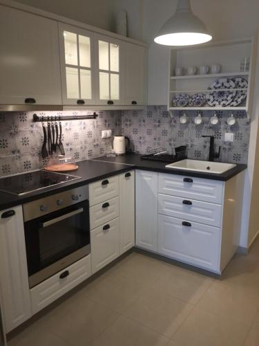 a kitchen with white cabinets and black counter tops at Goldfish Seaside Luxury Houses in Kómi