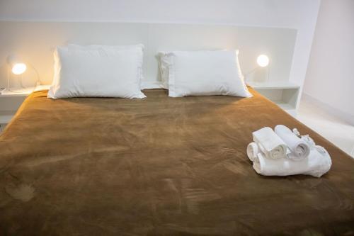 a bed with two white towels on top of it at Atlântida Green Square - 601B in Capão da Canoa
