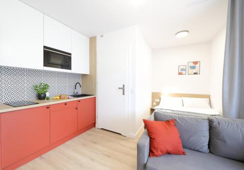 a living room with a couch and a kitchen at Apartamenty Meiera in Kraków