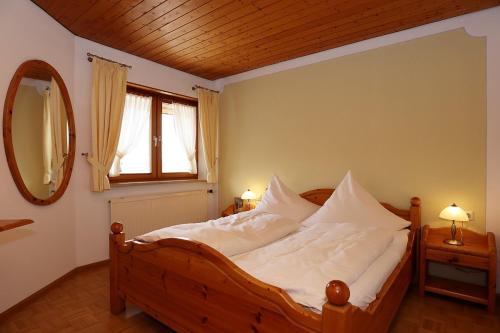 sypialnia z łóżkiem z białą pościelą i lustrem w obiekcie Gasthof Rebland w mieście Eichstetten