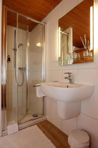 a white bathroom with a sink and a shower at Gasthof Rebland in Eichstetten