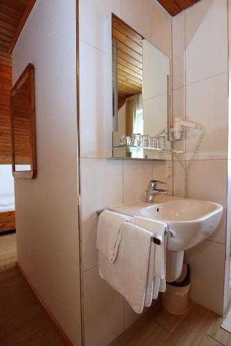 a white bathroom with a sink and a mirror at Gasthof Rebland in Eichstetten