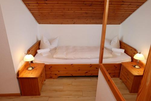 a small bed in a small room with two lamps at Gasthof Rebland in Eichstetten