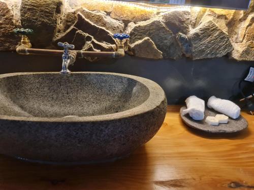 a bathroom with a stone sink on a wooden floor at HOTEL BOUTIQUE TIERRA DE ISLAS Chiloé in Castro