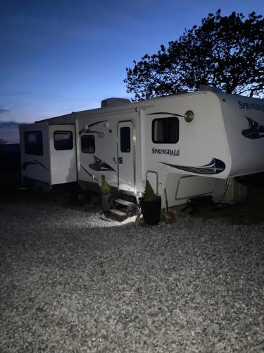 a white trailer parked in a gravel field at 5th Wheel Trailer in Bere Alston