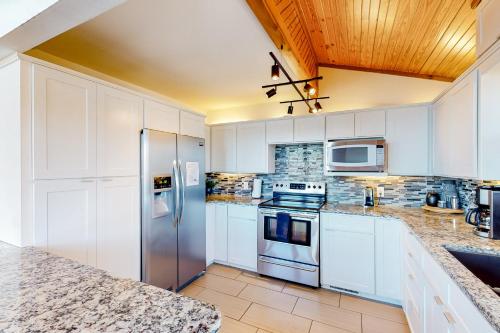 a kitchen with white cabinets and stainless steel appliances at Lost Rock in Rogers