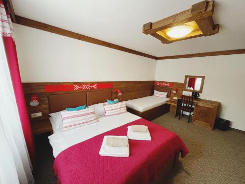 1 dormitorio con 1 cama grande con manta roja en SPA & WELLNESS Penzión Zorhill, en Ždiar