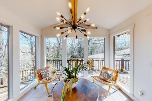 a dining room with a table and chairs and a chandelier at Lost Rock in Rogers