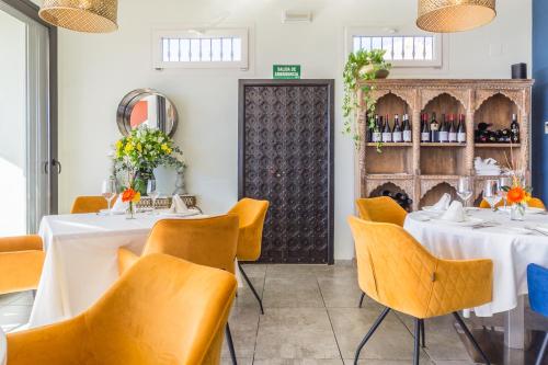 a dining room with white tables and orange chairs at Hotel Miba in Salobreña