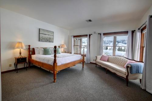 a bedroom with a bed and a couch and a window at Casia Lodge and Ranch in Twisp