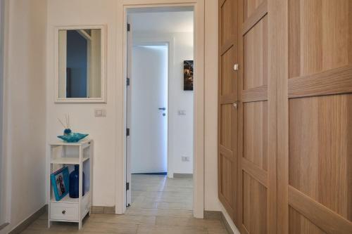 a hallway with a wooden door and a small cabinet at That's Amore Capri in Anacapri