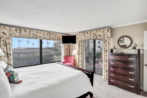 a bedroom with a large bed and a large window at B110 Amelia Surf and Racquet in Fernandina Beach