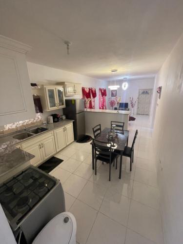 uma cozinha e sala de jantar com mesa e cadeiras em Mount Royal Estate Cozy Comfort em Portmore